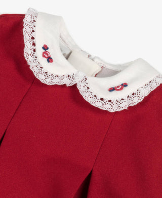 Red garment with white lace collar featuring red and blue embroidery on a white background
