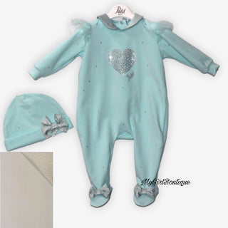 Petit Italia cream baby grow it has scattered crystals all over, cream tulle fabric on the shoulders. It has a silver collar and silver bows on the feet. The matching cream hat has scattered crystals and a silver bow on the front. 