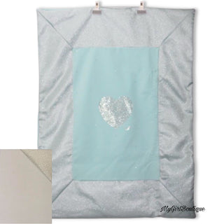 Cream girls blanket by Petit, it has embellished crystals in a heart design in the middle and crystals scattered all over. It has the petit logo written in crystals across the middle.