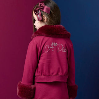 A Dee girls burgundy jacket with faux fur collar, faux fur cuffs and diamanté logo on the back