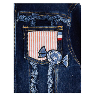 Close-up of a denim pocket with a candy-themed patch on a white background