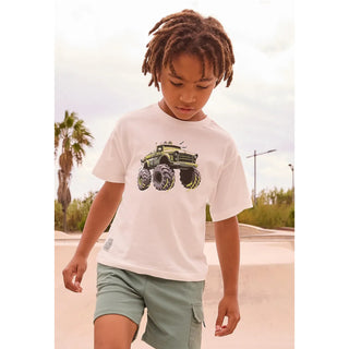 Child wearing a white t-shirt with a green monster truck graphic outdoors.