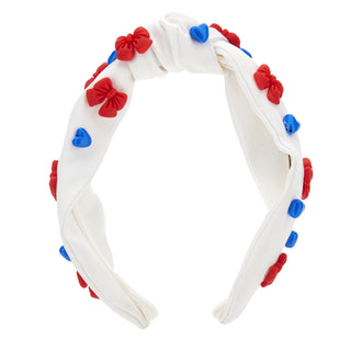 White headband with red, blue, and white bow decorations by Monnalisa on a white background 